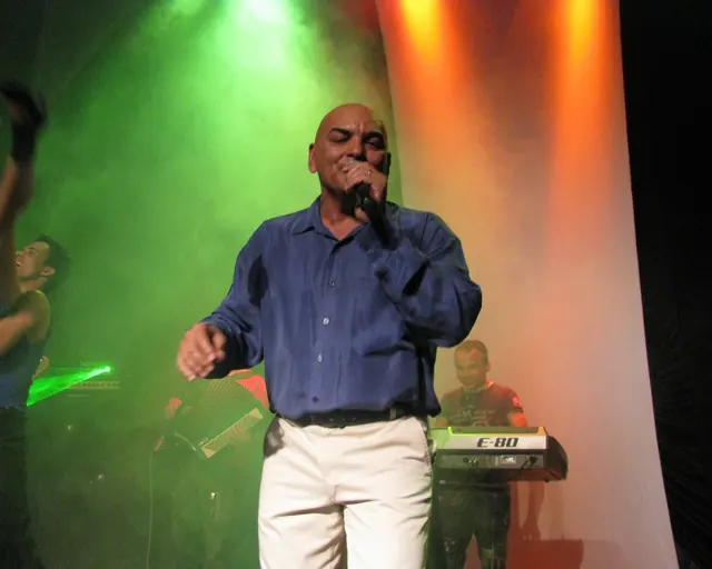 Marcos Fernandes cantando em show com luzes e fumaça