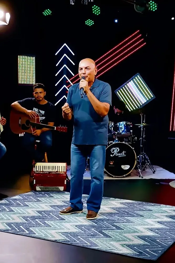 Marcos Fernandes cantando no palco com a banda